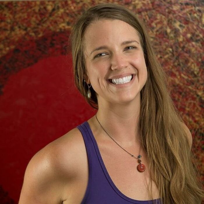 Young woman smiling confidently in a sleeveless top, representing obsession with her therapist in a controversial story.