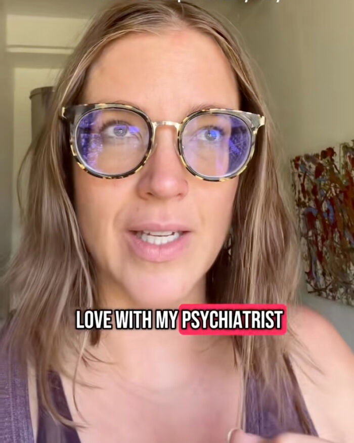 A woman wearing glasses talks about being obsessed with her therapist in a casual indoor setting.