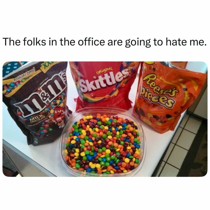 Colorful candy mix of M&M's, Skittles, and Reese's Pieces on a table with caption about office, related to neurodivergence memes.