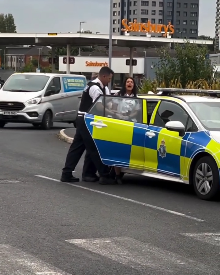 Police officers detaining a person near a patrol car outside a Sainsbury's, new details emerge after video outrage.