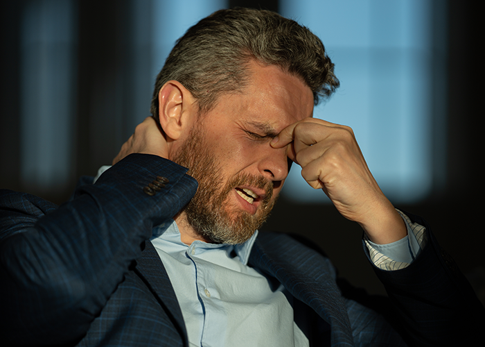 Man in a suit showing frustration and stress, symbolizing conflict in a relationship with daughter over marriage in his yard.
