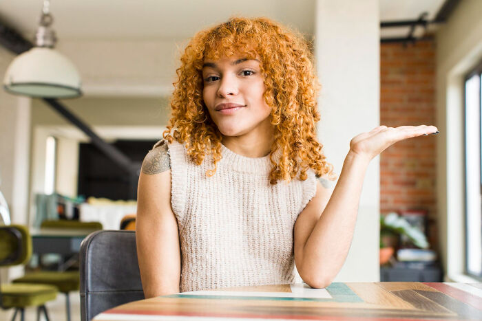 Young woman with curly hair in a casual setting representing everyday sexism and pressure women face as normal.