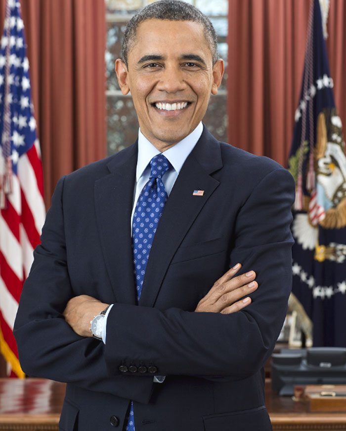 Barack Obama smiling confidently in suit and tie with American flags behind, symbolizing his net worth and global media shift.