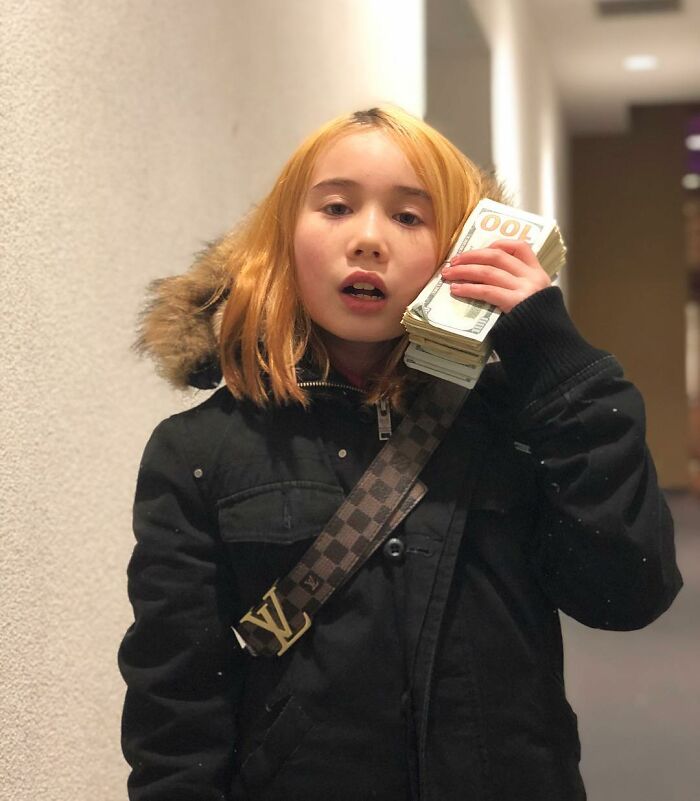 Young adult star holding cash to face in hallway, representing adult star and OF encouragement keywords. Young adult star holding cash to face in hallway, representing adult star and OF encouragement keywords.