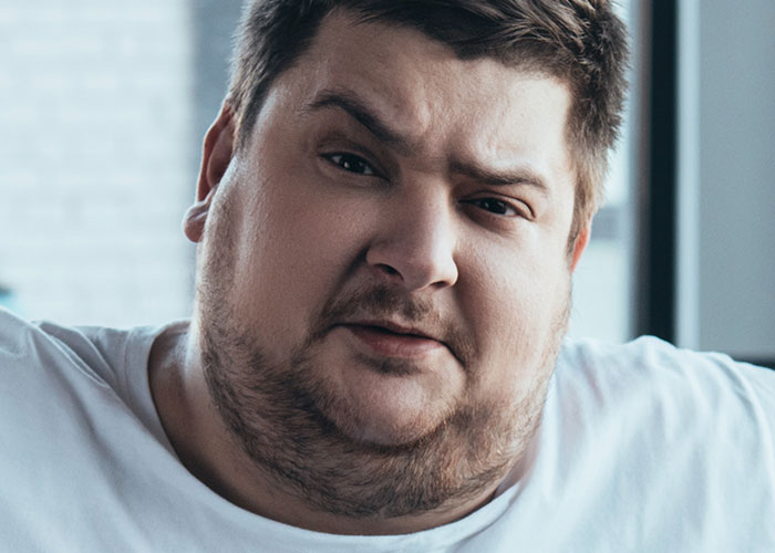 Man with determined expression standing up to train bully who ends up huffing and puffing after losing.