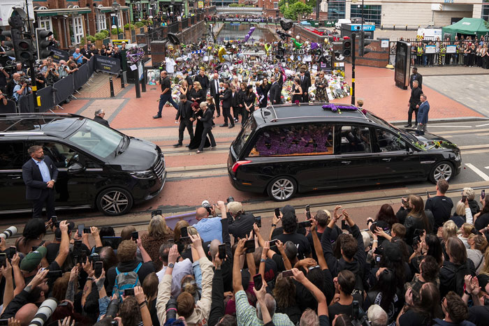 Crowd gathers around hearse carrying Ozzy Osbourne&rsquo;s coffin, with lawyers explaining buying his house with grave legal implications.