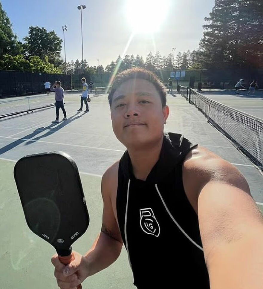 Man holding paddle on outdoor court, bright sunlight in background, relating to in-flight showdown bathroom law breaking incident. Man holding paddle on outdoor court, bright sunlight in background, relating to in-flight showdown bathroom law breaking incident.