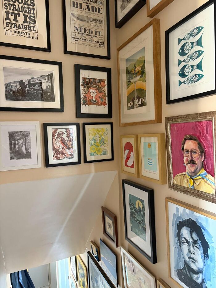 Wall gallery of framed art and prints decorating a home staircase, showcasing unique decor pieces for a magical atmosphere.