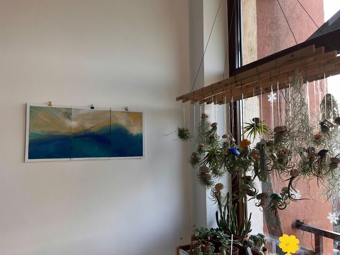 Abstract wall art and hanging plants decorating a cozy corner, highlighting decor pieces that enhance magical home spaces.