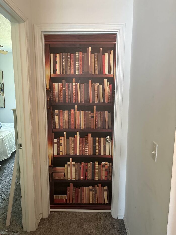 Door decorated with a bookshelf decal featuring old books, a unique decor piece that makes homes more magical and cozy.
