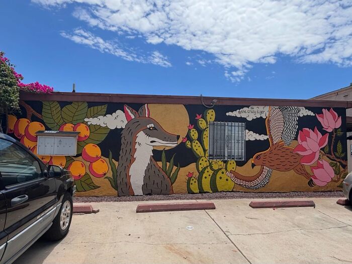 Colorful mural decor piece with animals and plants enhancing outdoor home space under a bright sky