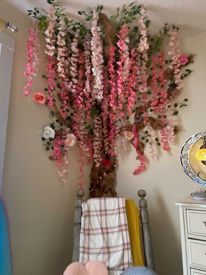 Floral wall decor piece with pink and white flowers creating a magical home atmosphere above a wooden chair.