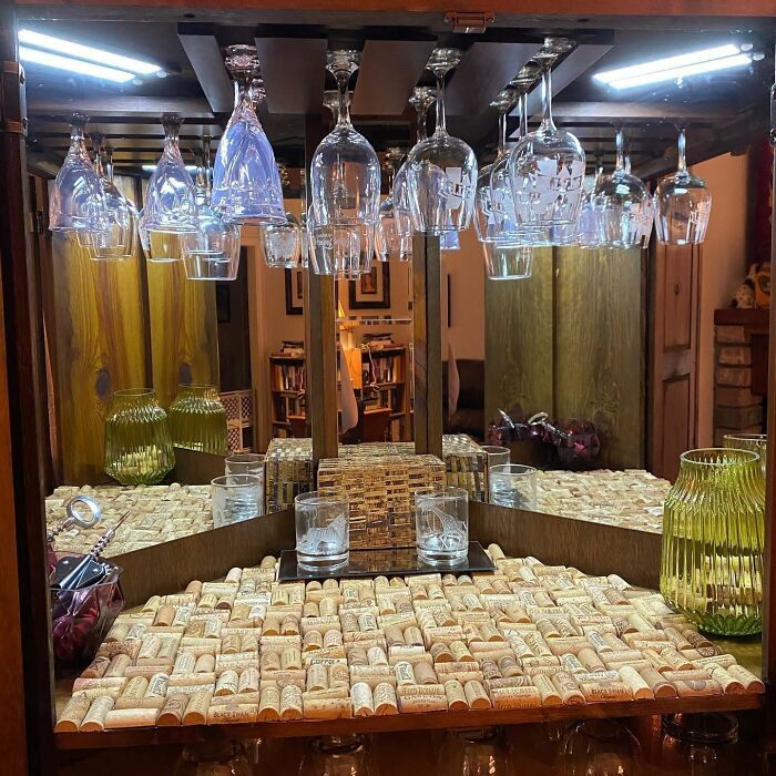 Home bar decorated with wine corks and hanging glassware, showcasing unique decor pieces for a magical home atmosphere.