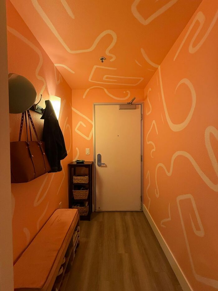 Cozy entryway with magical home decor pieces featuring abstract orange wall art and functional storage solutions.