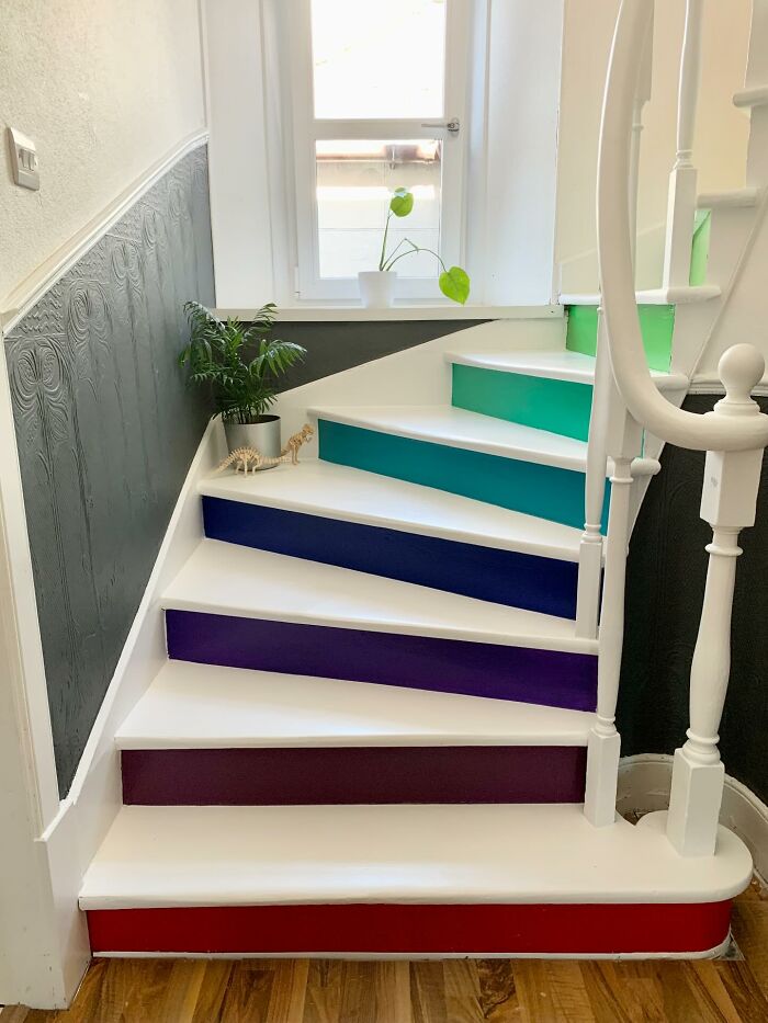 Colorful painted stair risers in a home staircase with potted plants decorating the corner, adding magical decor pieces charm.
