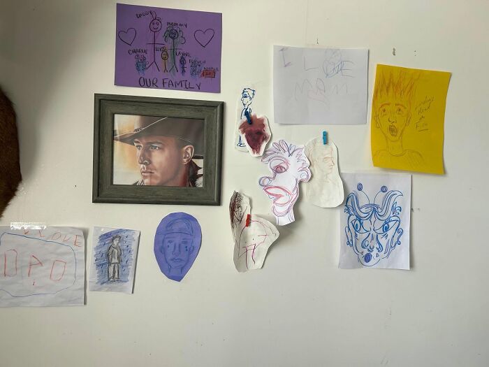 Wall decorated with framed portrait and various colorful hand-drawn decor pieces creating a magical home atmosphere