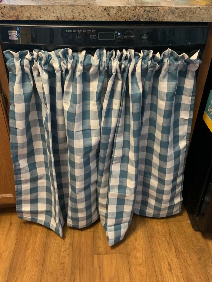 Blue and white checkered fabric decor piece covering a dishwasher, adding cozy charm to home interiors.