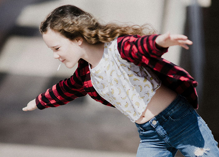 Young girl with curly hair playing outside, embodying the mysterious and unexplained moments people personally experienced.