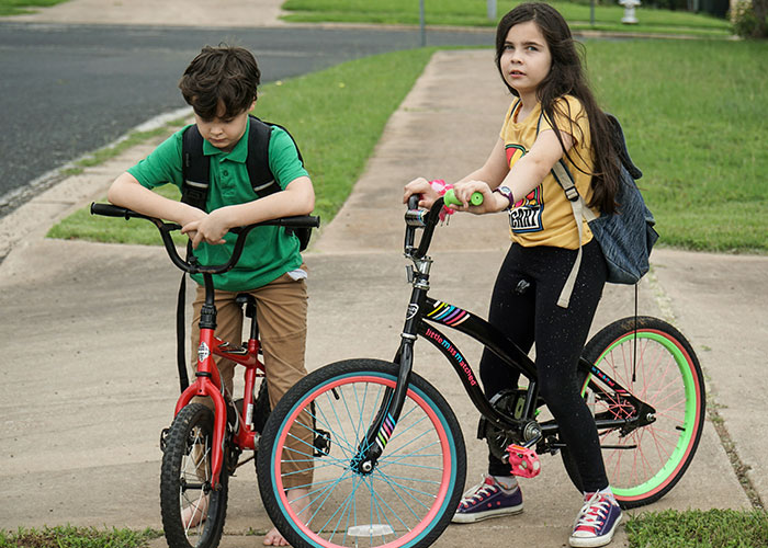 Two children with backpacks on bikes, appearing confused, illustrating mysteries people personally experienced and can’t explain.