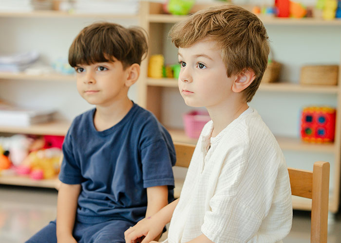 Two young boys sitting in a classroom, highlighting mysteries people personally experienced they still can’t explain.