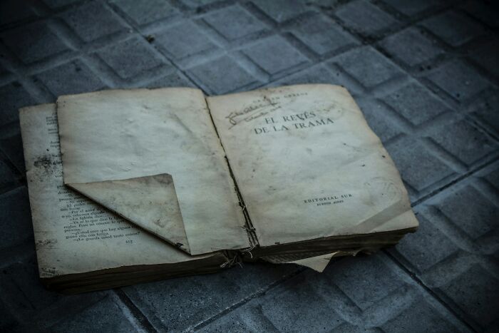 Old open book with worn pages resting on a tiled floor, illustrating industry secrets being revealed. - 7
