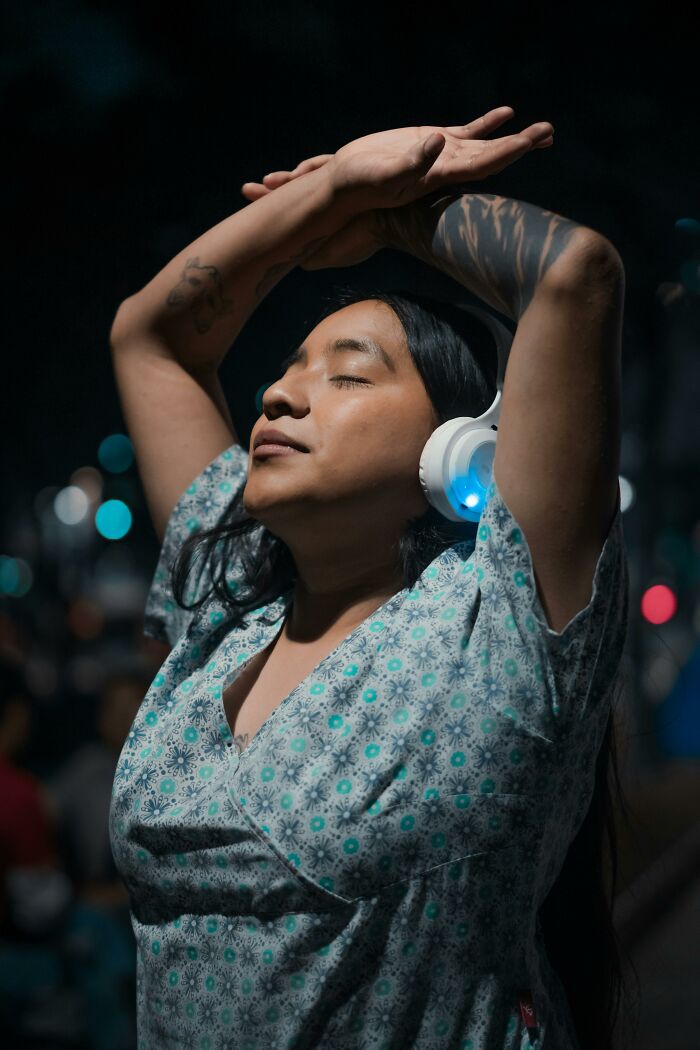Person wearing headphones and a patterned shirt, enjoying music with eyes closed, illustrating things people thought were a flex.