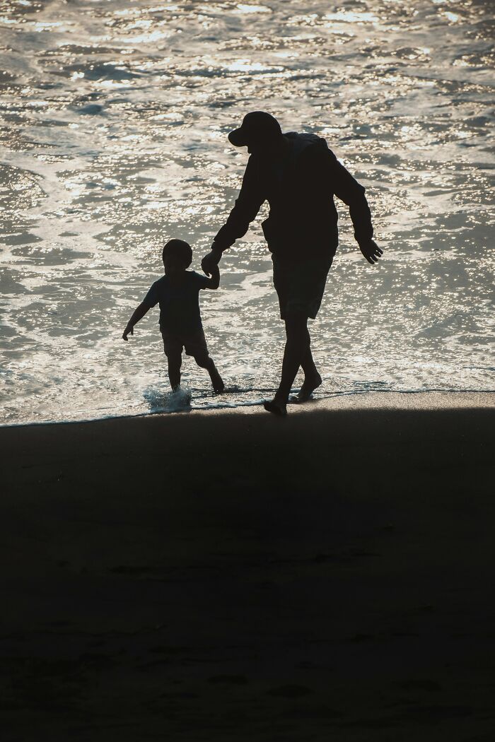 Man and child walking on the beach at sunset, illustrating moments people thought were a flex but actually aren’t.