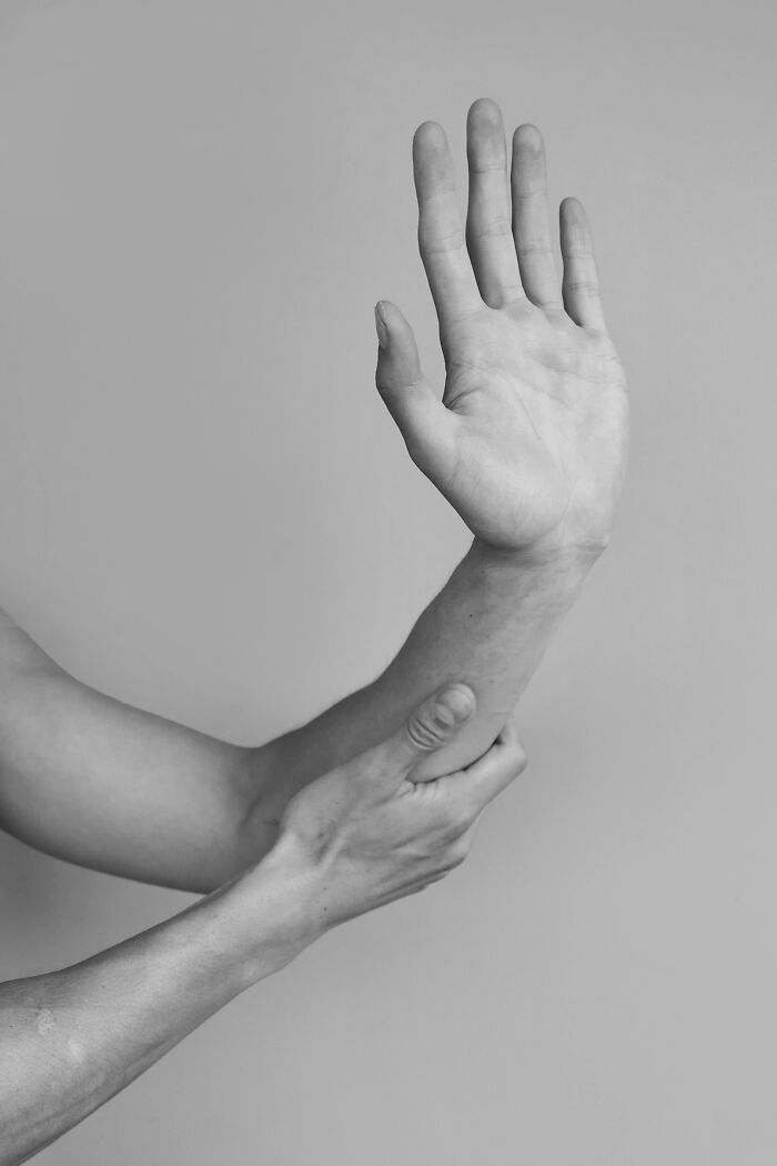 Close-up of a person holding their raised arm, representing discomfort and disturbing facts people shared.