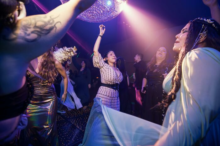 People dancing under a disco ball at a party, captured in vibrant lighting moments of deciding to leave the scene.