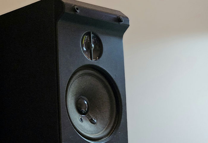 Close-up of a black speaker in a room, illustrating noisy neighbors often causing petty disputes online.