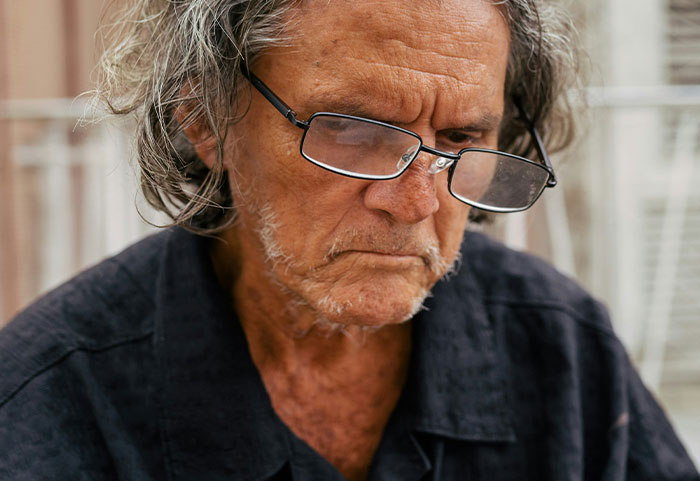 Older man wearing glasses with a serious expression, representing petty neighbors featured in online shaming posts.