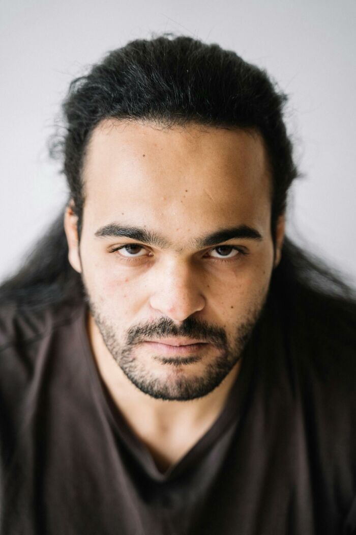 Close-up portrait of a man with intense gaze and dark hair, illustrating traits of talking to a psychopath.
