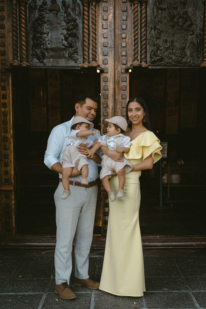 Family of four standing in front of ornate wooden doors, smiling and dressed elegantly, related to psychic predictions.