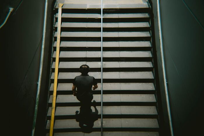 Person walking up stairs in a dimly lit area, evoking a mysterious atmosphere related to psychic predictions.