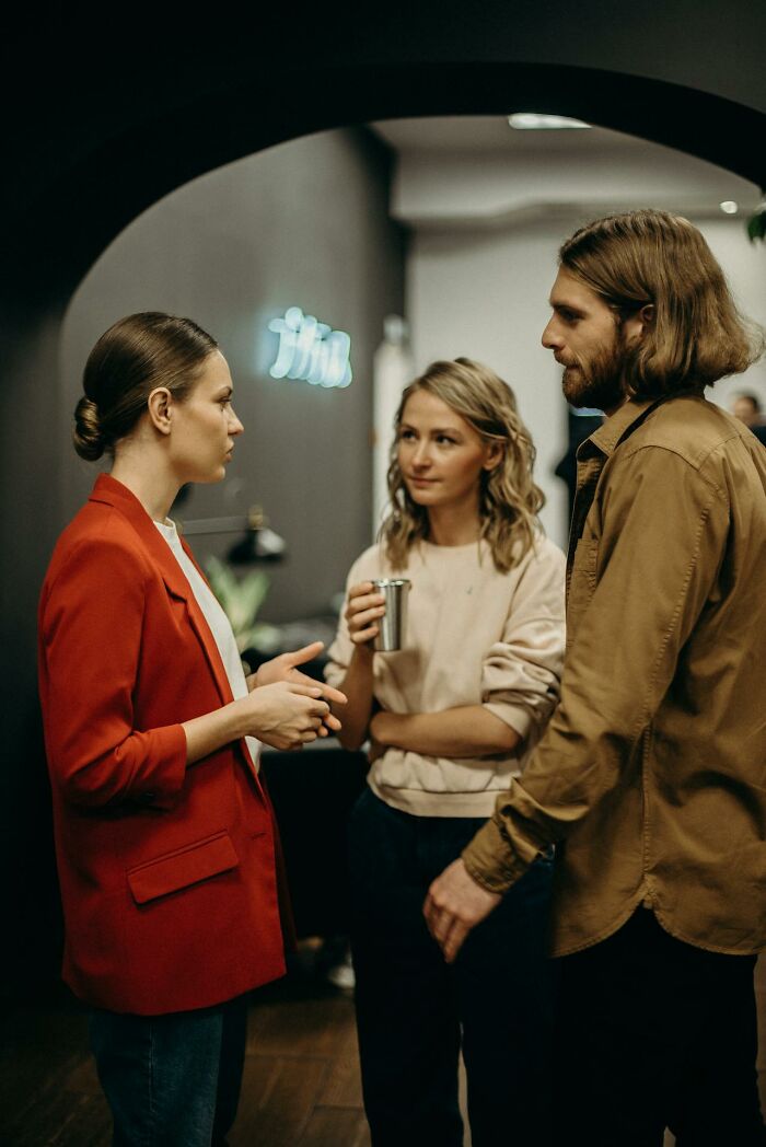 Three people engaged in a serious conversation, illustrating a moment of realizing they’re talking to a psychopath.