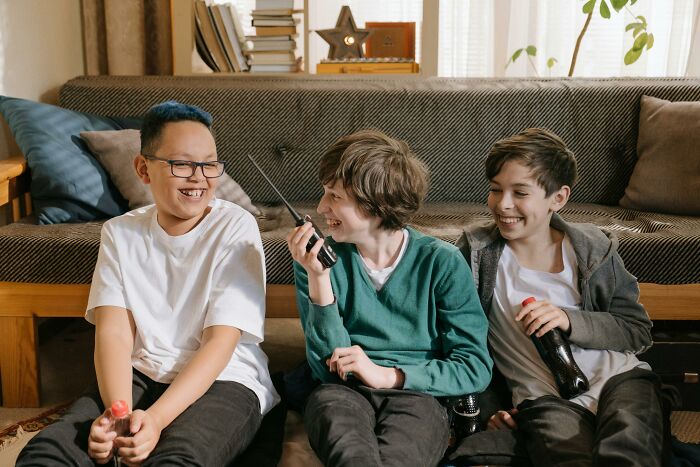 Three boys sitting on a couch laughing and holding a walkie-talkie and soda, capturing terrifying things people swear they've seen.