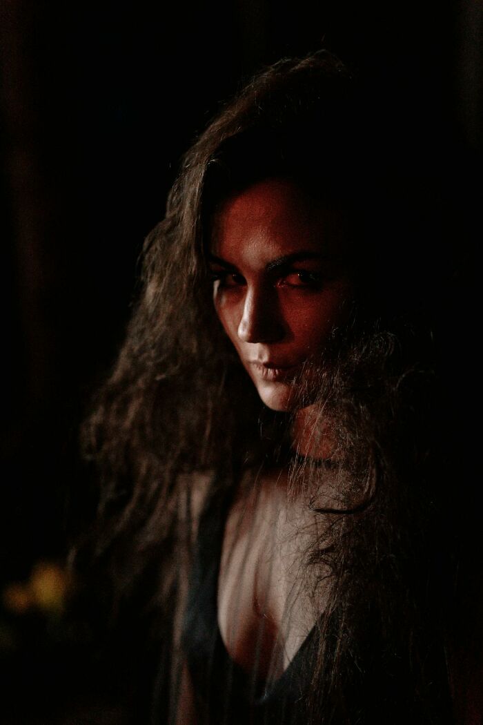 Woman with long dark hair in low light, creating a creepy and terrifying atmosphere related to kids' imaginary friends.