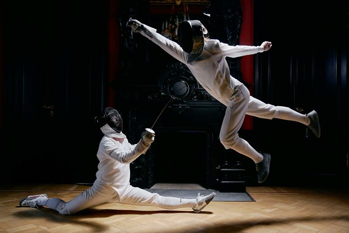 Two fencers in full gear demonstrating agility and precision, illustrating picking the wrong line superpowers concept.