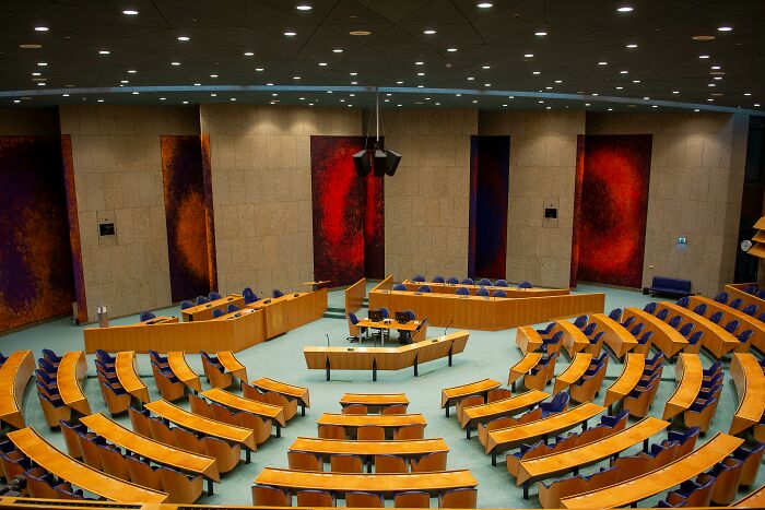 Empty legislative chamber with curved seating arrangement, representing concepts of USA direct democracy and governance.