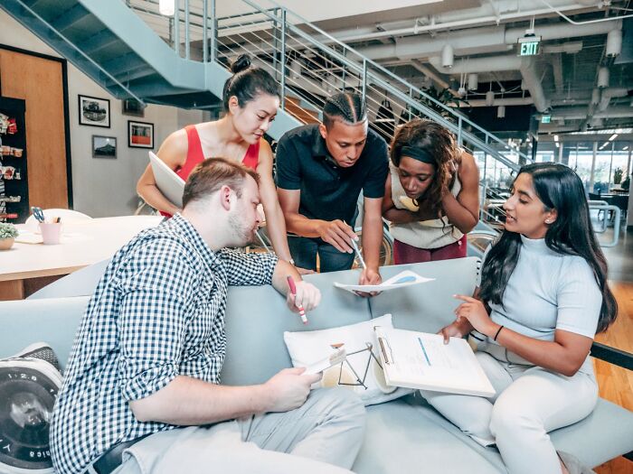 A diverse group of professionals collaborating in an office, highlighting job interview red flags and toxic workplace signs.