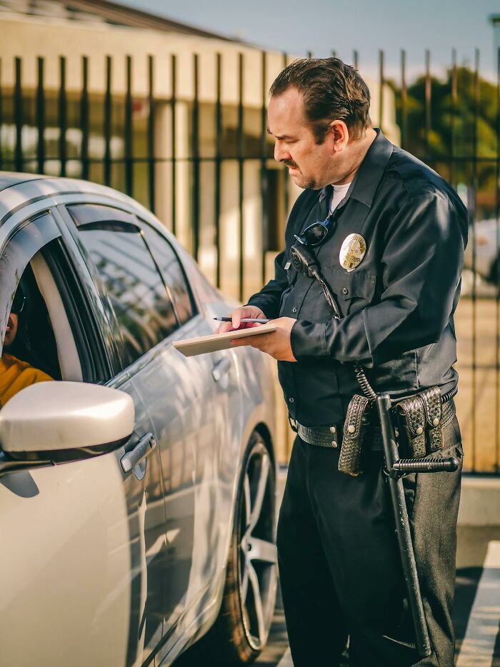 Police officer writing a ticket for a driver, illustrating PR campaigns and decisions that were complete and utter fails.