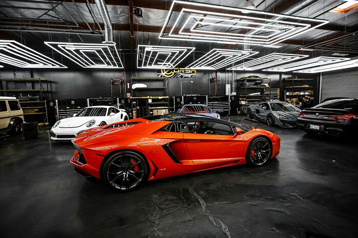 Luxury sports cars in a high-end garage illustrating wealth gap and extreme financial disparity perspectives.