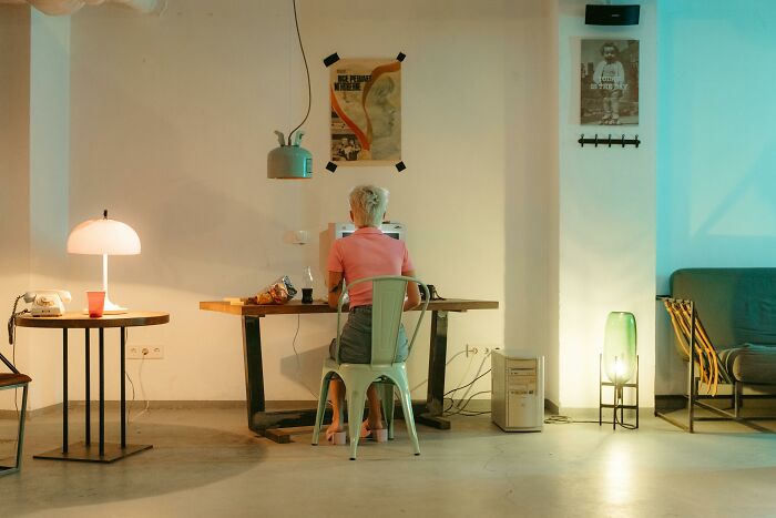 Person working at a desk in a modern room, illustrating creative ways people avoid babysitting shared online.