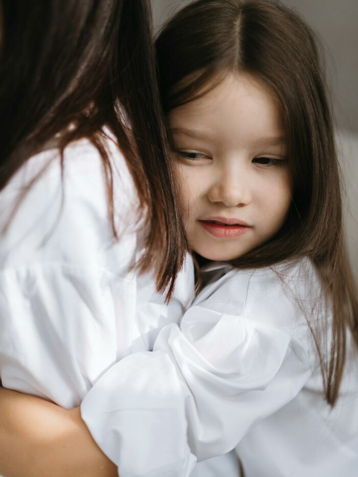 Young girl hugging an adult, depicting a moment tied to creepy and terrifying experiences with kids' imaginary friends.
