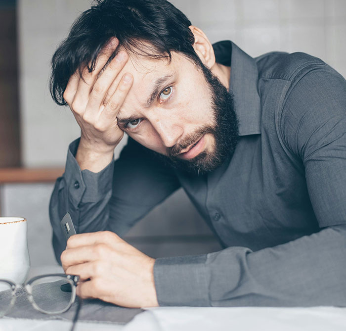 Man looking heartbroken, holding glasses, reflecting on a failed proposal and desire for a rich husband over hardworking partner. Man looking heartbroken, holding glasses, reflecting on a failed proposal and desire for a rich husband over hardworking partner.