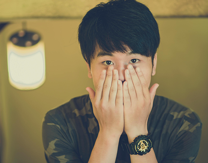 Young man covering face with hands, expressing surprise, related to body count and relationship exposure topics. Young man covering face with hands, expressing surprise, related to body count and relationship exposure topics.