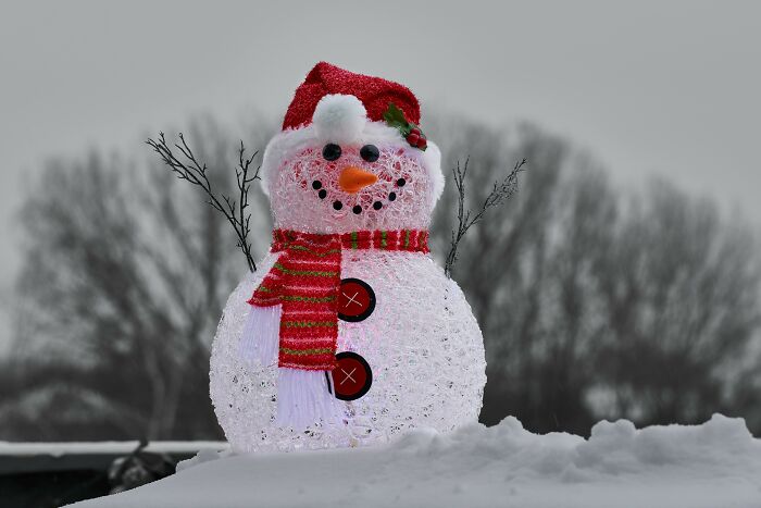 Lighted snowman dressed in a scarf and hat, illustrating creative ways people avoid babysitting during winter.