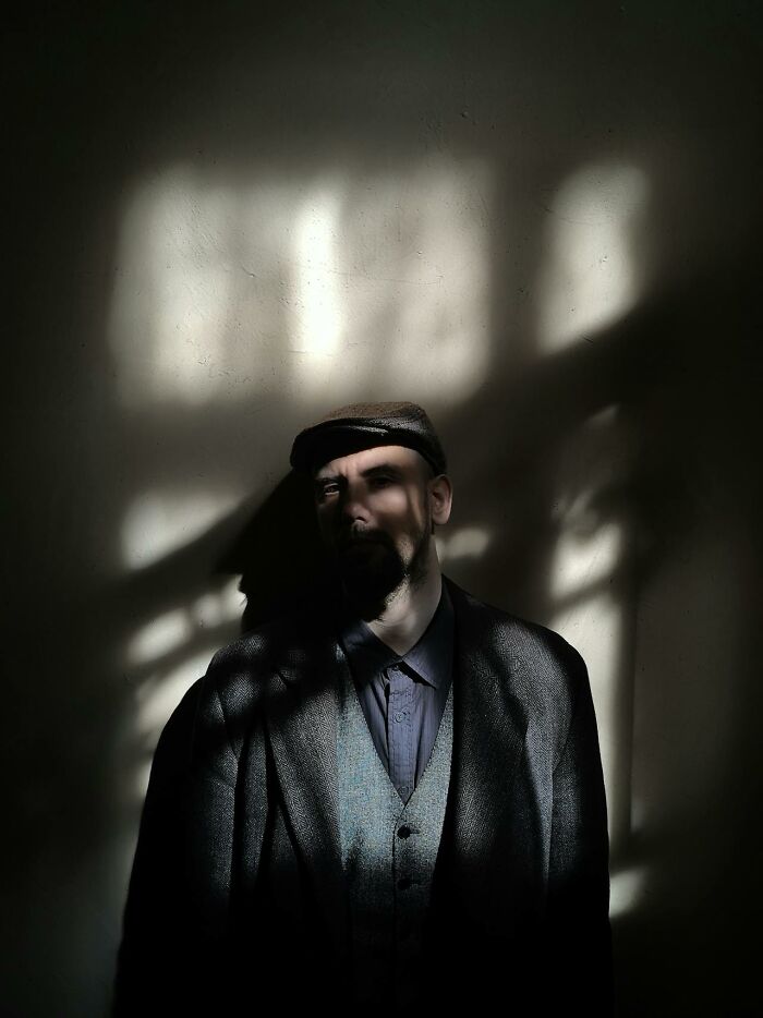 Man in dark vintage clothing with eerie shadows on his face, evoking creepy and terrifying imaginary friend experiences.