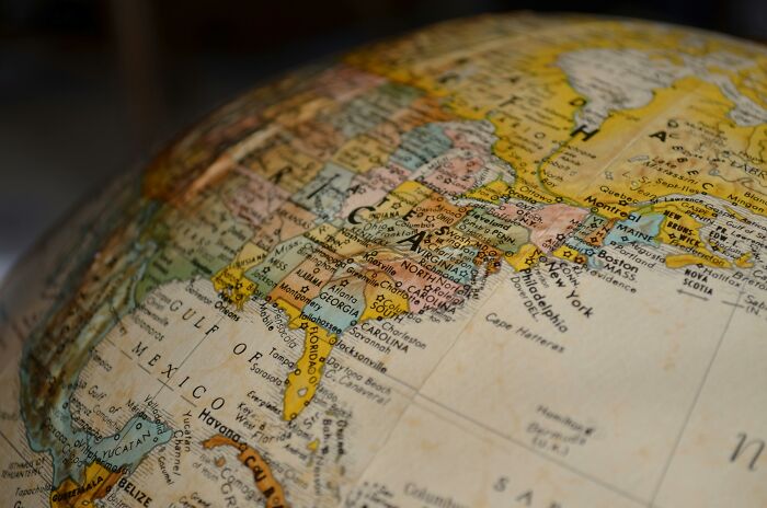 Close-up of a globe showing countries and cities with names in different languages for geography and language learning.