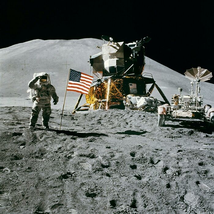 Astronaut saluting next to American flag on the moon, showcasing iconic historical events like the moon landing. Astronaut saluting next to American flag on the moon, showcasing iconic historical events like the moon landing.